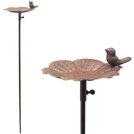 Arrosoir de jardin avec un oiseau sur une feuille