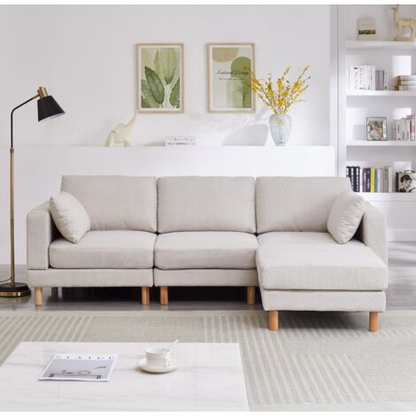 Canapé d'angle trois places de style nordique avec pouf, dimensions 235×152×78 cm – Canapé beige en forme de L, en tissu polyester et pieds en bois massif, adapté aux salons modernes.