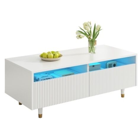 Cette table basse moderne à LED est dotée d'un plateau à tiroirs ondulé, de pieds dorés et blancs, de deux tiroirs et de bandes lumineuses LED à couleurs changeantes. Un meuble TV assorti est égalemen