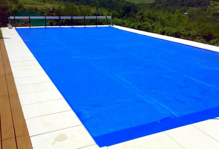 Avvolgitore telescopico Kokido Deluxe Presto 3D su piscina coperta da telo blu isotermico.