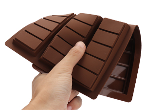 une main tenant une barre de chocolat