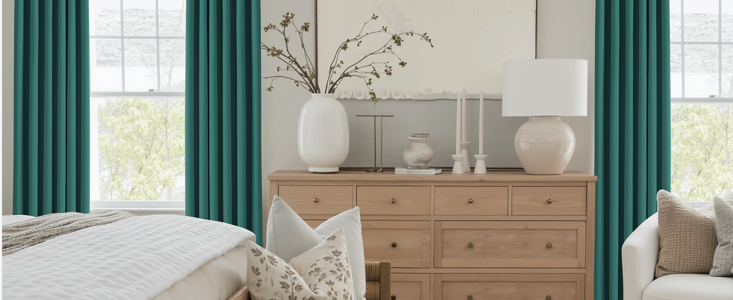 Intérieur lumineux du salon avec commode en bois naturel, rideaux blancs et vases décoratifs. Les grandes fenêtres fournissent un éclairage naturel.