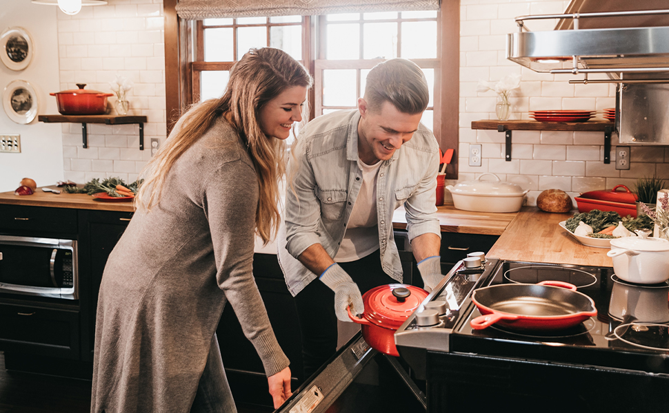 Deux personnes cuisinent ensemble dans une cuisine, en utilisant des casseroles sur une cuisinière. Ils semblent préparer un repas à la maison.