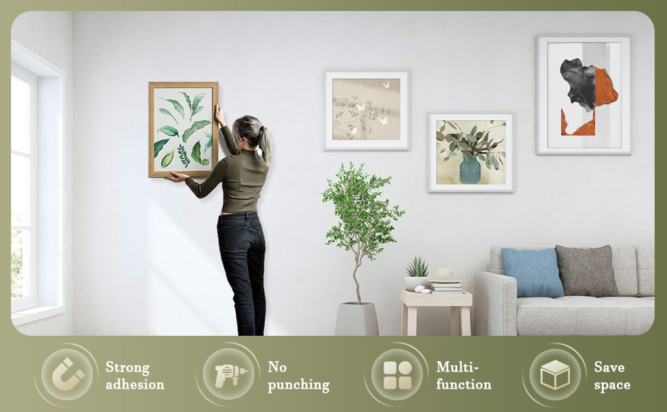 une femme met une photo sur un mur.