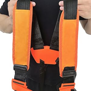Mains tenant les sangles oranges et noires d'un harnais ou d'un équipement de sécurité. Les bretelles sont dotées de boucles réglables et de coutures renforcées