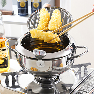 Pentola per fonduta in acciaio inossidabile con olio bollente, tempura immersa con le bacchette. Posizionato su un fornello con bottiglie
