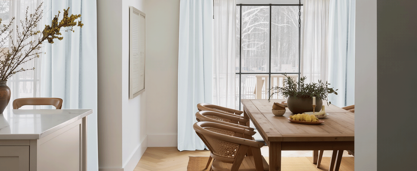 Interior view of the room with a dining room with a wooden table, chairs and a window with curtains.