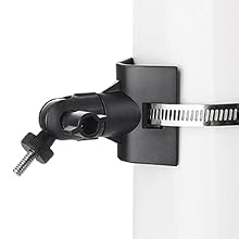 Pince de fixation en métal noir avec vis réglable et ouverture circulaire, fixée à un objet cylindrique blanc par une bande métallique.