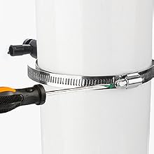 Le collier de serrage métallique est serré autour d'un objet cylindrique blanc à l'aide d'un tournevis à manche orange. La pince est équipée d'une vis sans fin pour le réglage. <p class=