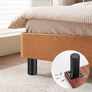 Pieds de meuble réglables en métal noir présente sur un cadre de lit en bois. L'image en encart montre un pied unique muni de vis, ce qui montre qu'il est facile à installer sur un meuble. data-src=
