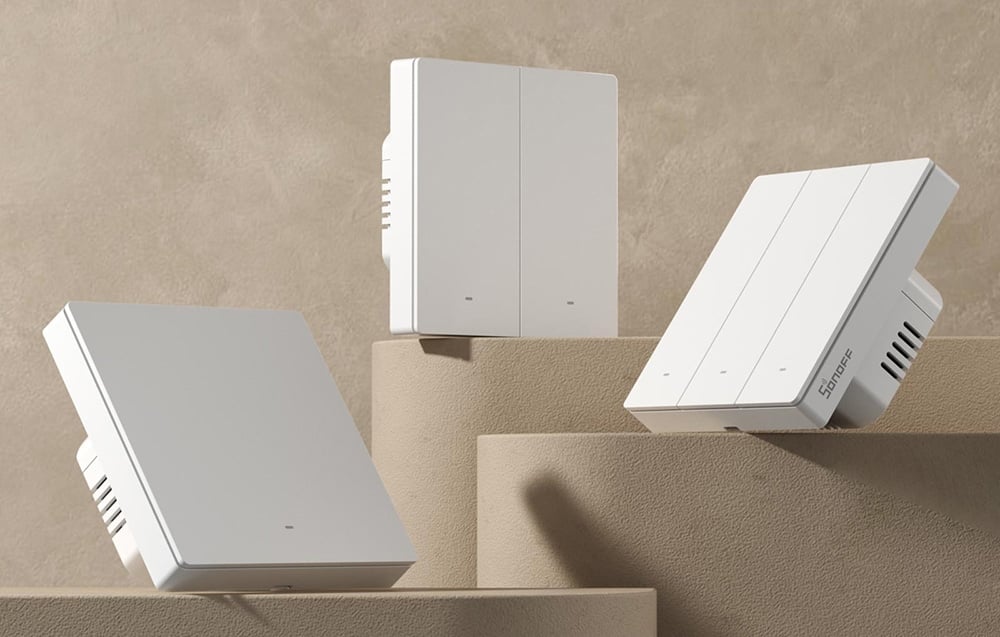 Tres interruptores inteligentes SONOFF blancos de diferentes tipos dispuestos en bloques geométricos beige