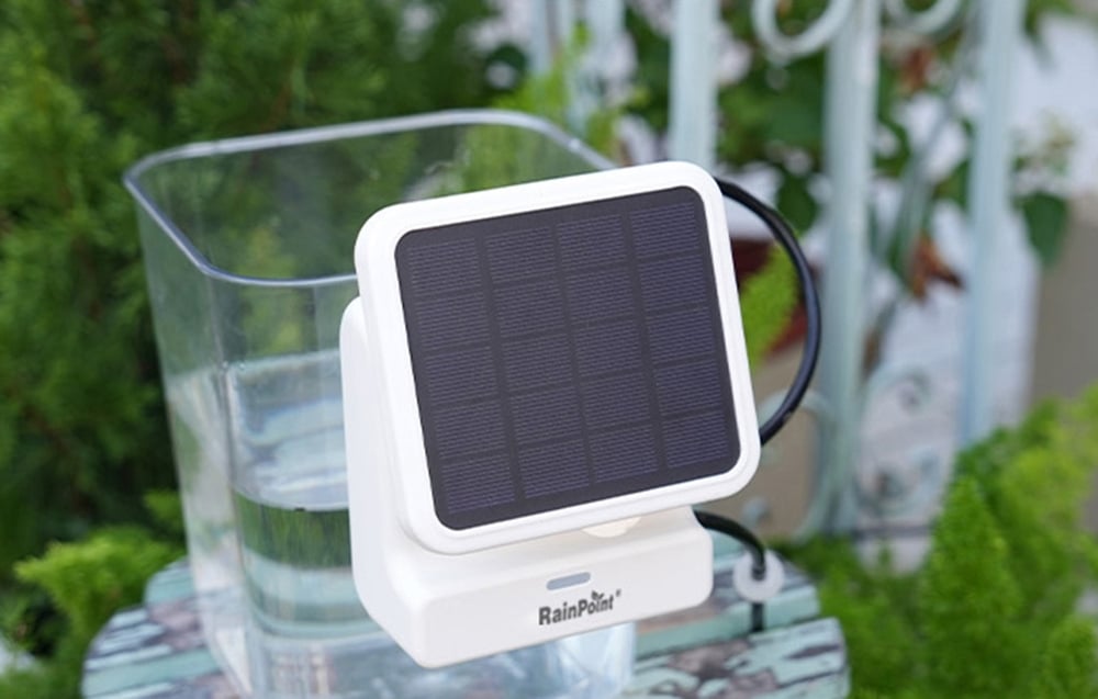 Pannello solare RainPoint accanto a un contenitore d'acqua su un balcone o in giardino