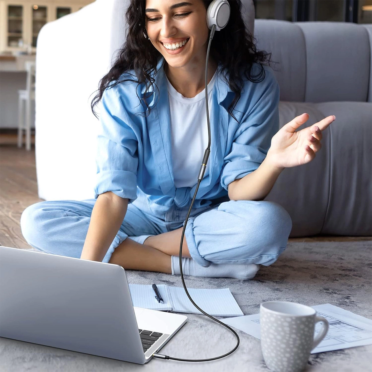 Mujer escuchando música con auriculares conectados a un ordenador con un cable Ugreen AV118