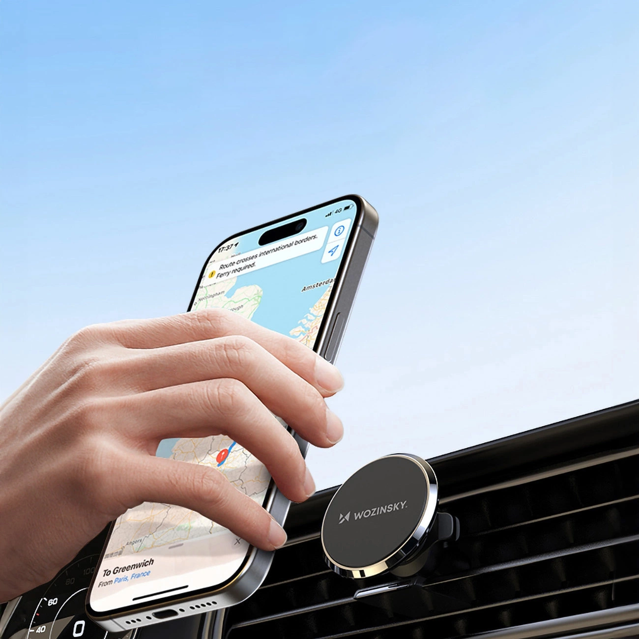 Mano colocando un iPhone en el soporte magnético para coche Wozinsky WUMKO montado en la rejilla de ventilación del coche