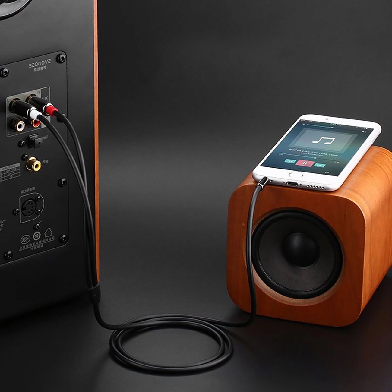 Teléfono sobre un altavoz con el cable Ugreen AV116 conectado directamente al amplificador de audio