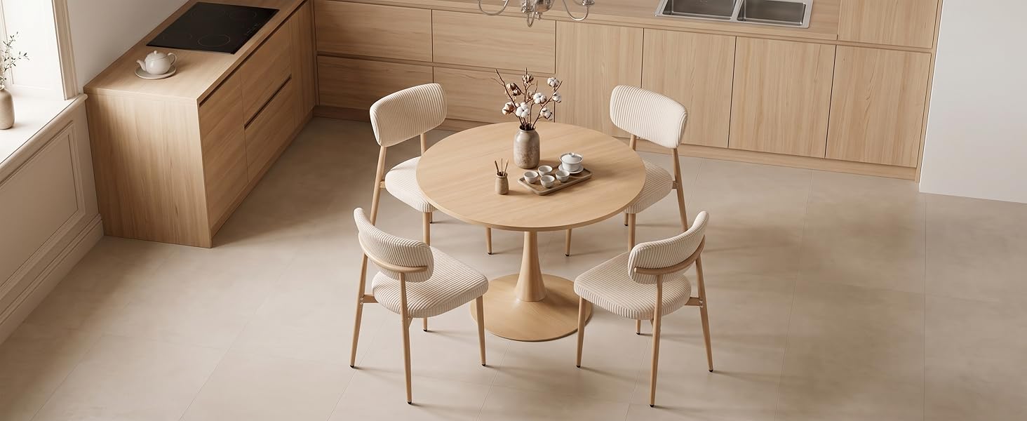 Espace intérieur avec table à manger ronde en bois et quatre chaises rembourrées beiges. Des lambris sur les murs, des sols de couleur crème et un design de mobilier minimaliste de style scandinave.