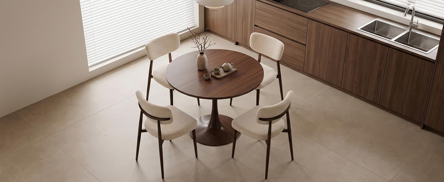Salle à manger intérieure moderne comprenant une table ronde en bois avec quatre chaises assorties de style milieu du siècle, une étagère en bois accrochée au mur et un éclairage naturel éclatant provenant de grandes fenêtres.