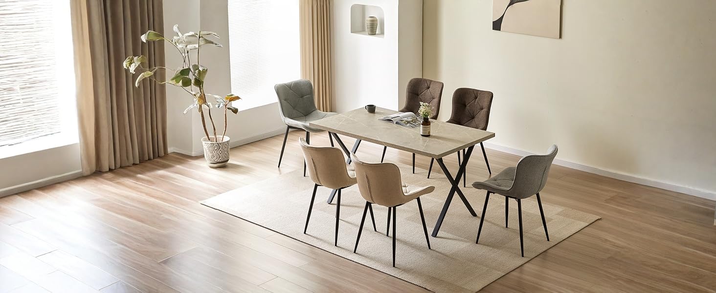 Modernes Esszimmer mit hellem Holztisch, vier schwarzen Stühlen mit Naturholzbeinen, Pendelleuchten, großen Fenstern mit Vorhängen und hellem Holzboden.