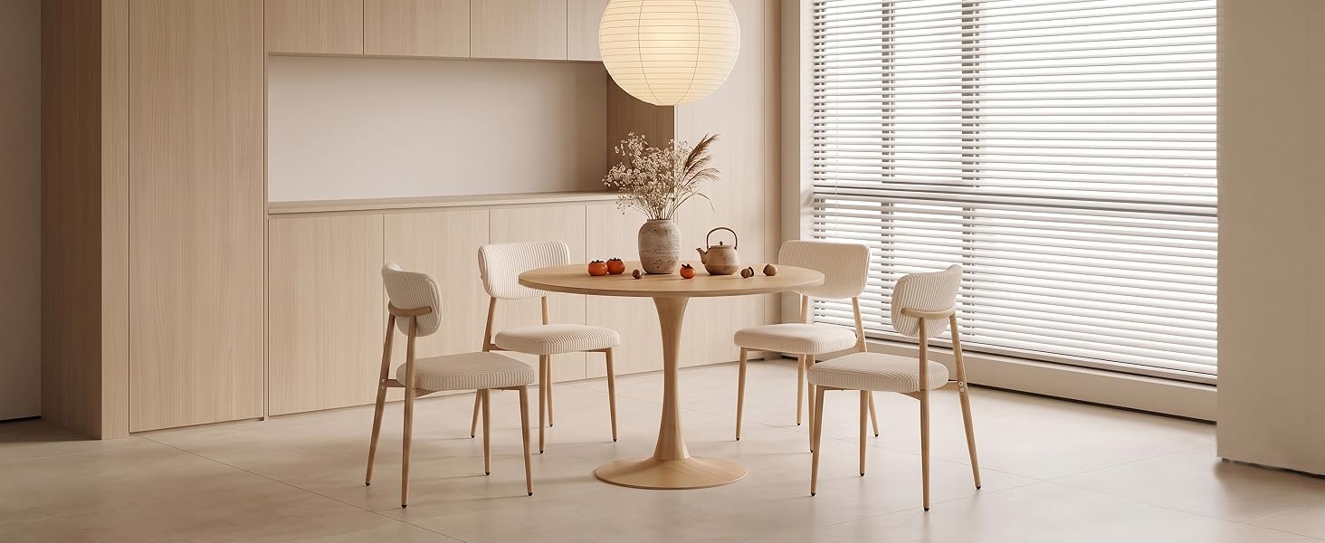 Salle à manger intérieure minimaliste avec des meubles en bois clair, des matériaux naturels, une table ronde avec des chaises, des baies vitrées avec stores horizontaux, une palette de couleurs neutres avec des tons de bois chauds.