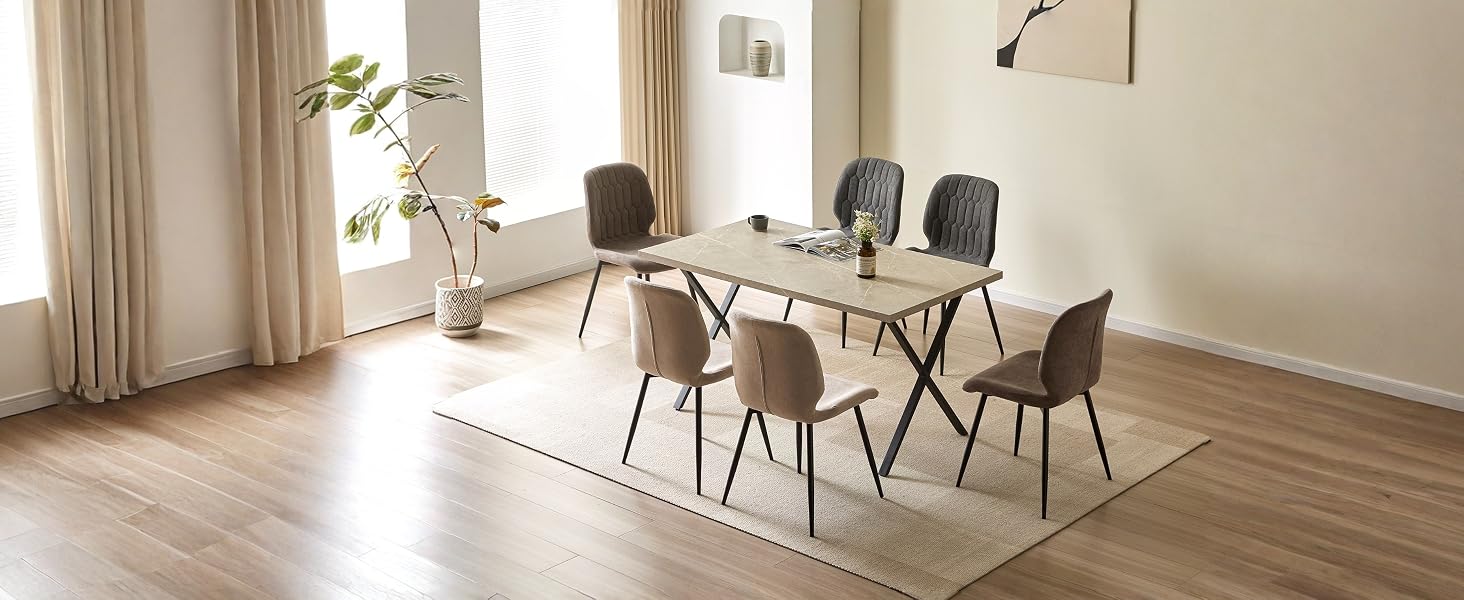 Moderner Essbereich mit rundem weißen Tisch, schwarzen Stühlen, Pendelleuchten, Holzboden, minimalistisches Innendesign in hellem Raum.