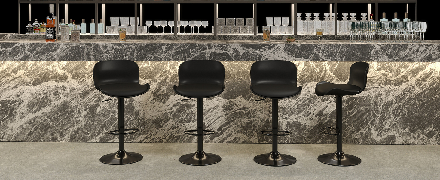Modern industrial-style bar setup with row of black metal bar stools against textured stone or concrete wall backdrop.