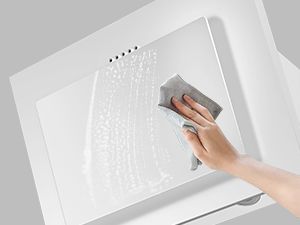 Essuyer ou nettoyer à la main une hotte de cuisine blanche ou une unité de ventilation de cuisine fixée au mur