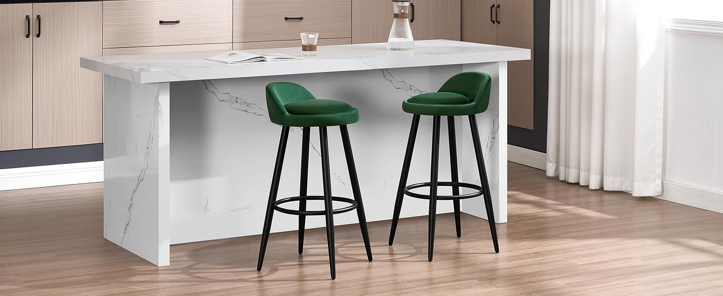 con efecto mármol blanco con dos taburetes tapizados en terciopelo verde. La isla tiene un diseño elegante y moderno con una encimera lisa