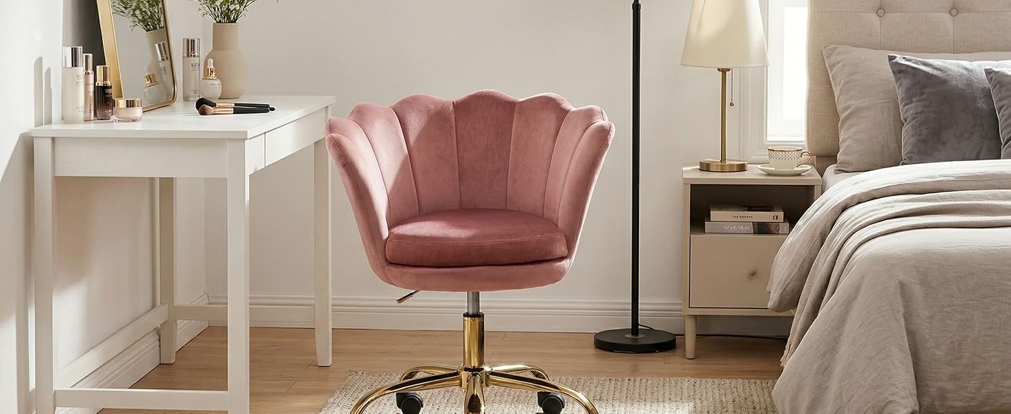 Décoration intérieure moderne avec chaise à dossier en velours rose sur des murs blancs et des sols baignés de lumière naturelle.