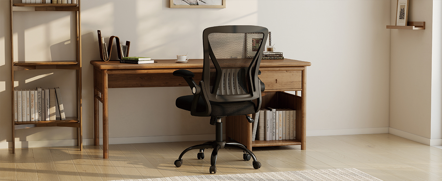 Chaise de bureau en maille noire positionnée sur un bureau en bois avec étagères dans un espace de travail domestique moderne. La chaise est dotée d'un dossier en maille, d'une base à roulettes et d'une hauteur réglable pour une assise ergonomique.