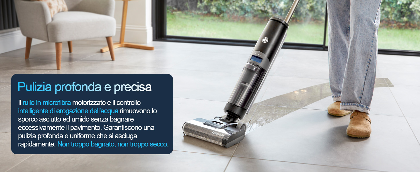 Il testo dice 'PULIZIA profonda e precisa'. Pubblicità del prodotto in lingua italiana che mostra un dispositivo nero per la pulizia dei pavimenti senza fili utilizzato su piastrelle bianche vicino alla finestra con i piedi visibili.