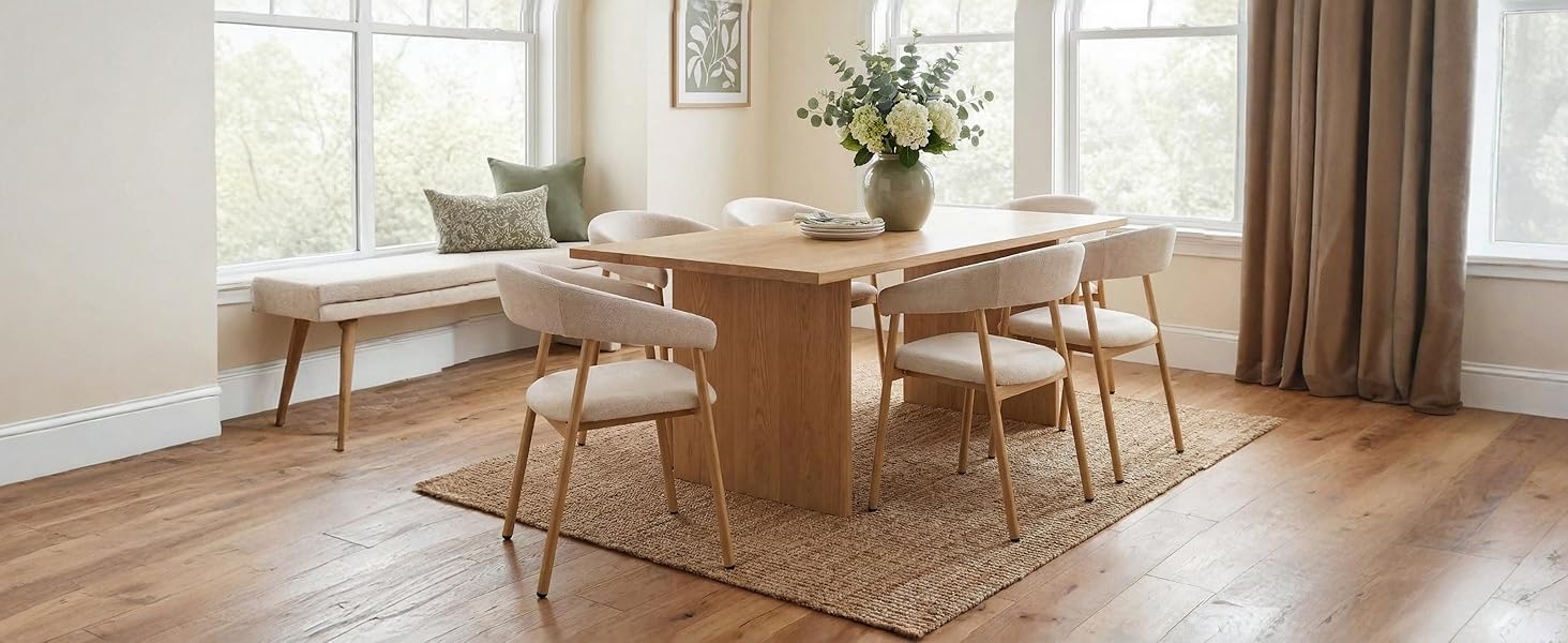 Modernes Esszimmerinterieur mit rundem Holztisch mit natürlicher Oberfläche, vier passenden Holzstühlen, weißer Pendelleuchte und dekorativem Topfpflanzenarrangement.