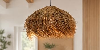 Gewebte Pendelleuchte mit kugelförmigem goldbraunem Rattanschirm, der von der Decke im hellen Innenraum mit sichtbarer Pflanze und Fenster hängt.