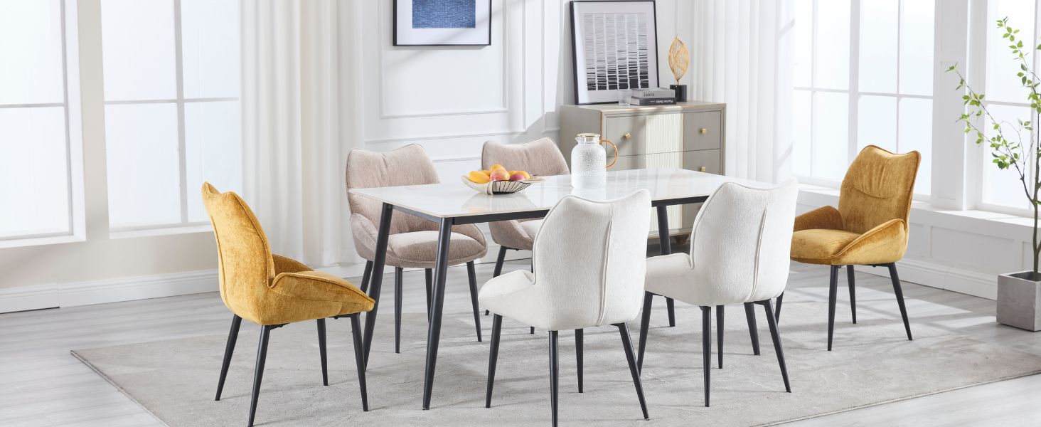 Set da pranzo moderno con tavolo in effetto marmo bianco, quattro sedie imbottite bianche e due sedie in velluto color senape in