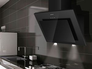 Hotte de cuisine inclinée noire avec éclairage LED, montée au-dessus d'une cuisinière dans une cuisine moderne aux murs carrelés