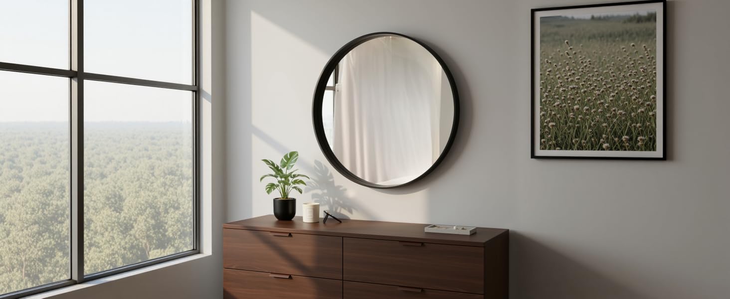 Interior room views showing a bathroom space with round mirror, wall art, and natural lighting through windows.