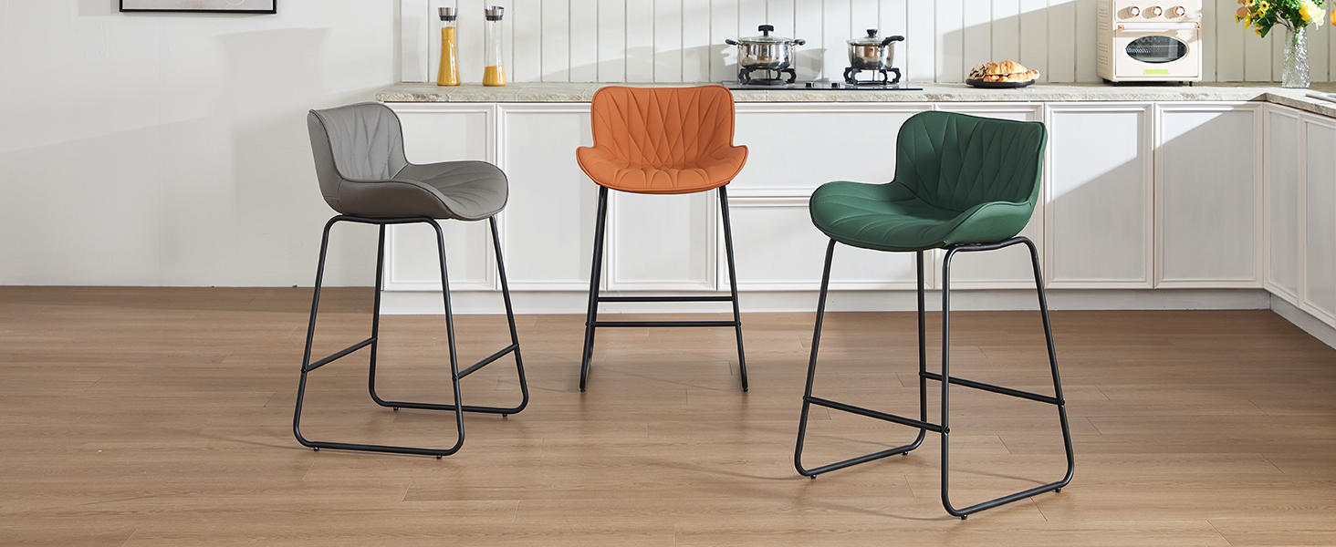 Three bar-height chairs in orange, dark green, and gray colors with metal frames and upholstered seats arranged in modern interior setting.