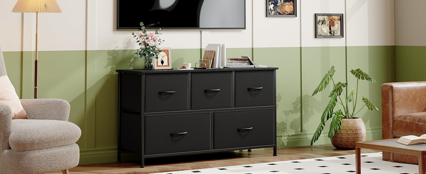 avec cinq tiroirs pour salon. Murs verts et blancs, lampadaire et plante en pot visibles. Le meuble a un design épuré et moderne.
