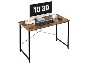 Scrivania per computer in legno con struttura in metallo nero. La configurazione del desktop include monitor, tastiera e orologio digitale con visualizzazione delle 10:39.
