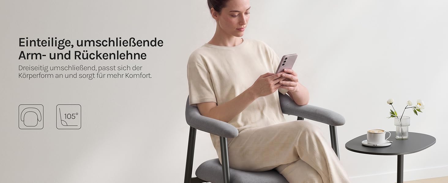 Der Text lautet „Einfach, umschließende Arm- und Rückenlehne“. Mann in beiger Kleidung sitzt auf einem Stuhl und hält ein Tablet-Gerät in der Hand. Beistelltisch mit sichtbarer Pflanze.