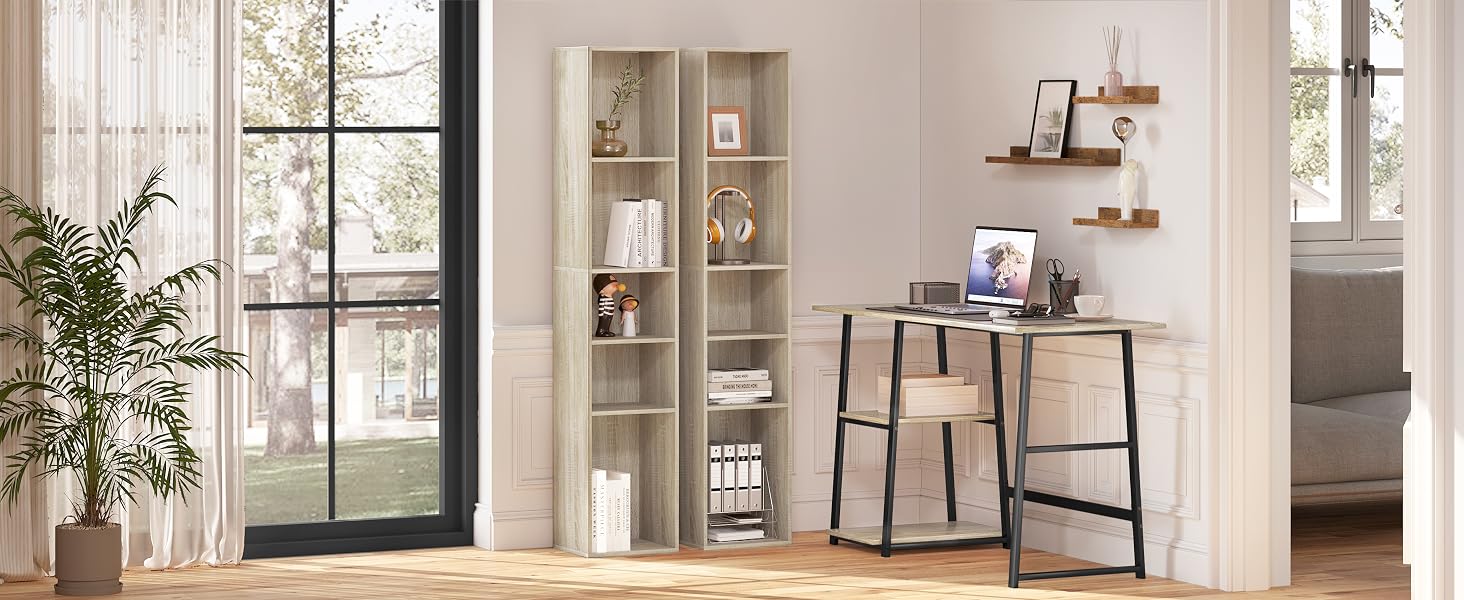 Home office setup with wooden desk, bookshelf, and floating shelves. Large window, potted plant, and decorative items visible.