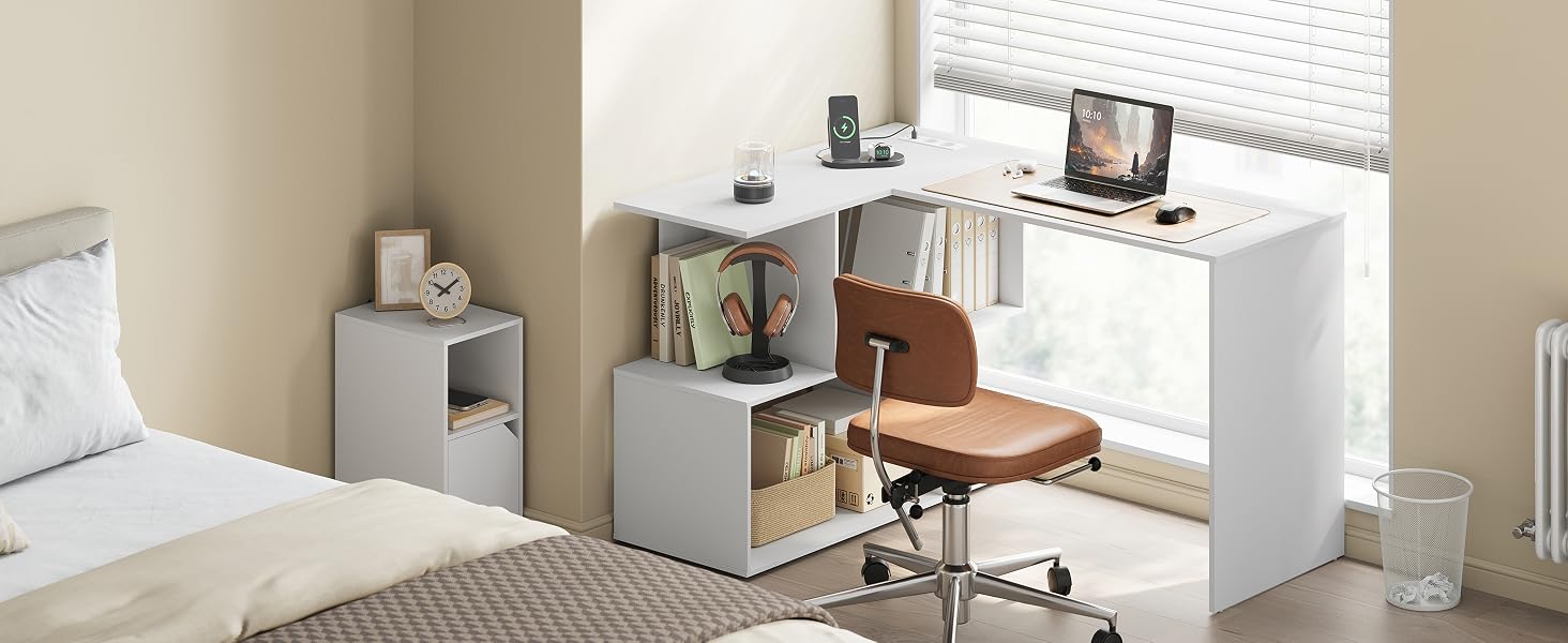 Configuración moderna de espacio de trabajo en el dormitorio con unidades de almacenamiento grises, escritorio blanco, silla de madera, monitor de computadora y estanterías organizadas con libros y artículos decorativos.