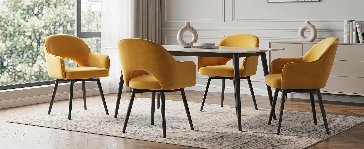Moderna sala da pranzo caratterizzata da un tavolo rotondo in legno con quattro sedie imbottite giallo senape con gambe in legno, posizionate su un tappeto grigio in uno spazio interno luminoso con finestre e tende.