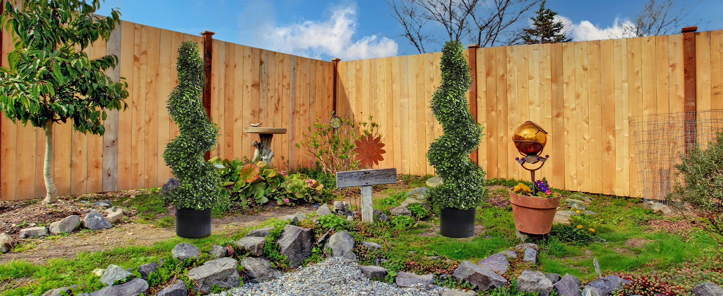 Outdoor garden or backyard scenes showing wooden fence installation or maintenance process under blue sky with green vegetation.