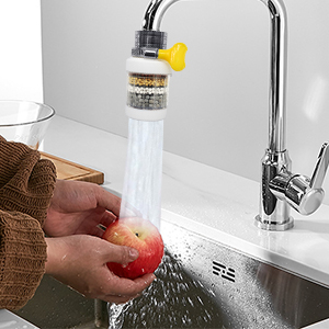 a person washing an apple in a sink