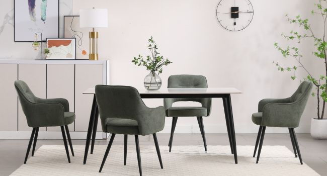 Modernes Esszimmer-Set mit mehreren grauen gepolsterten Stühlen, die um weiße Tische angeordnet sind, in einem hellen, minimalistischen Interieur mit dekorativen Pflanzen.