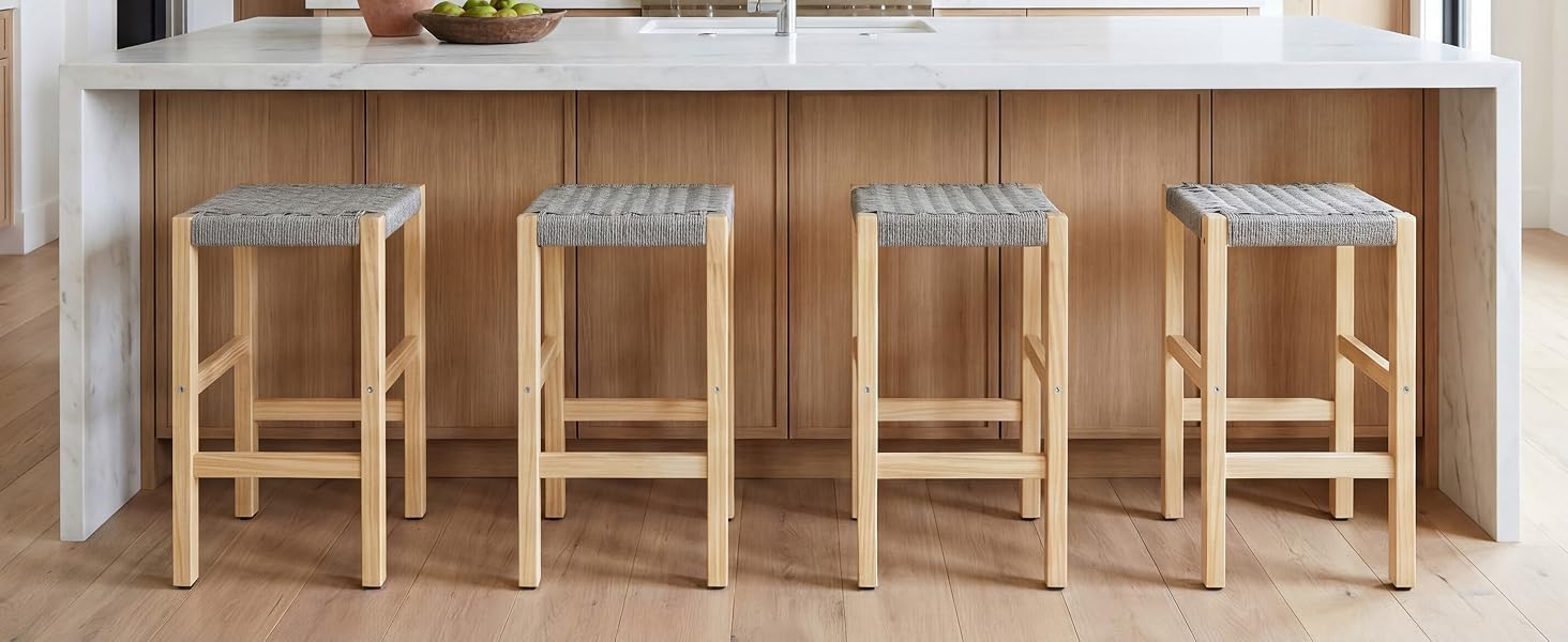 Rangée de quatre tabourets de bar identiques en bois avec finition naturelle, placés contre un comptoir ou un bar blanc.