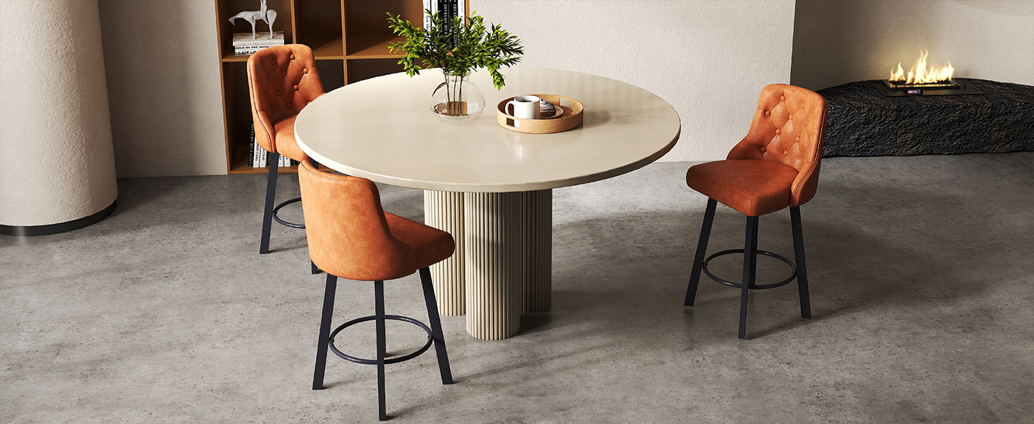 Modern dining setup with round concrete or stone table paired with orange upholstered chairs on metal frames in a minimalist space.
