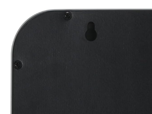 Close-up of a black, smooth surface with a curved edge and a small circular indentation, possibly part of an electronic device or case.