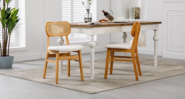 Dining set with white-based wooden table and two wooden chairs with cane-style backs.