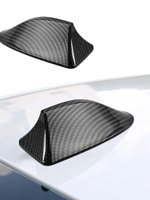 Black carbon fiber textured car antenna cover or 'shark fin' shown from two angles on a white surface.
